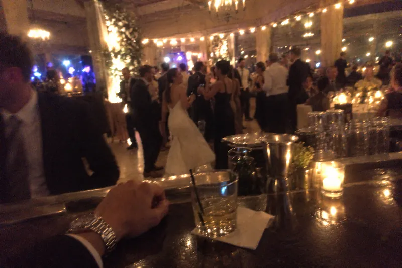 View from a wedding bar toward guests on a dance floor